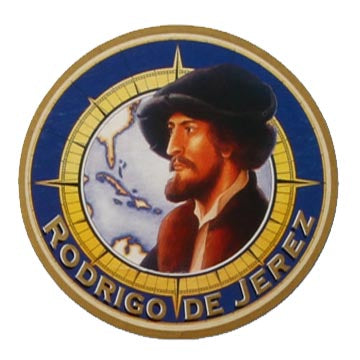 Round emblem showing a bearded Rodrigo de Jerez in front of a map of the Caribbean, with his name around the edge.